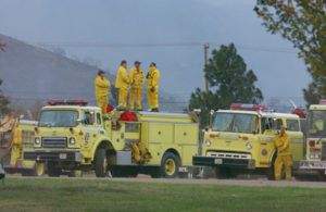 Men atop fire engines