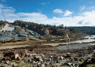 Heavy equipment work continues to remove the debris field in the diversion pool at the base of the damaged Oroville Dam spillway.