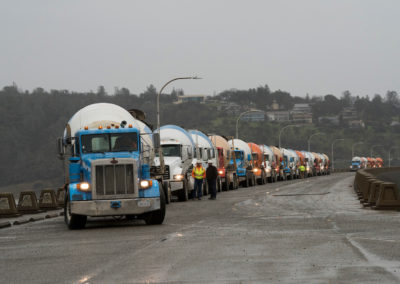 A long line of concrete trucks wait on the top of Oroville Dam to deliver concrete for the erosion repair work at the base of the Lake Oroville emergency spillway.
