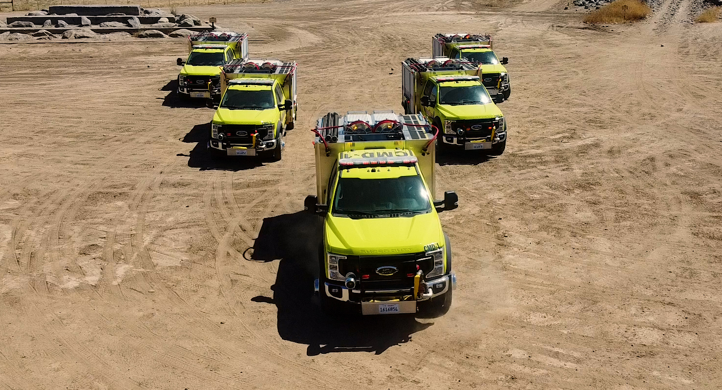 photo of 5 green fire engines in a "V" formation
