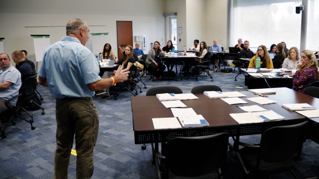 Image of a course instructor teaching students of the PIO Basics class.