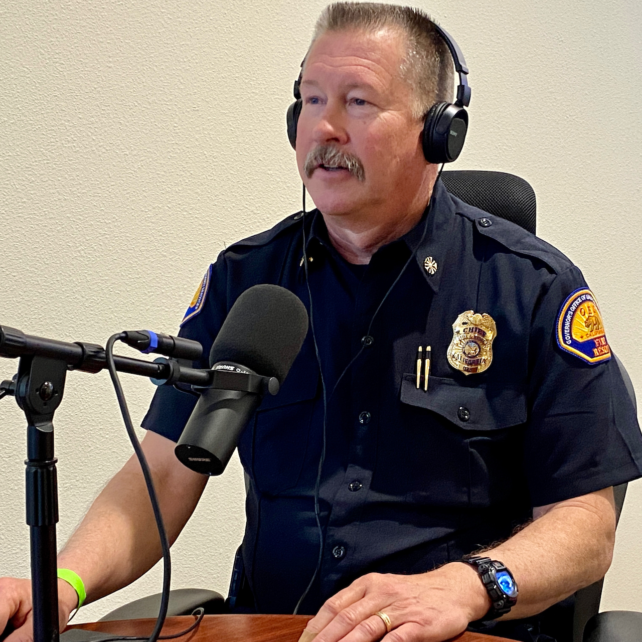 Chief Brian Marshall sitting down at table discussing fire readiness with recording equipment.