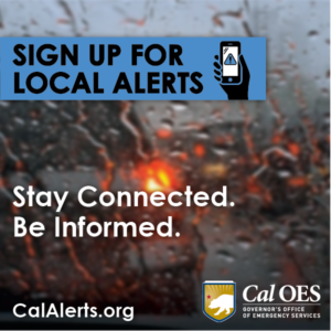 rainy car windshield with a car's red brake lights in the background. Text in blue banner reads sign up for local alerts with icon of a hand holding a mobile device. Text reads Stay Connected, stay informed. Cal alerts .org. cal oes logo in lower right corner
