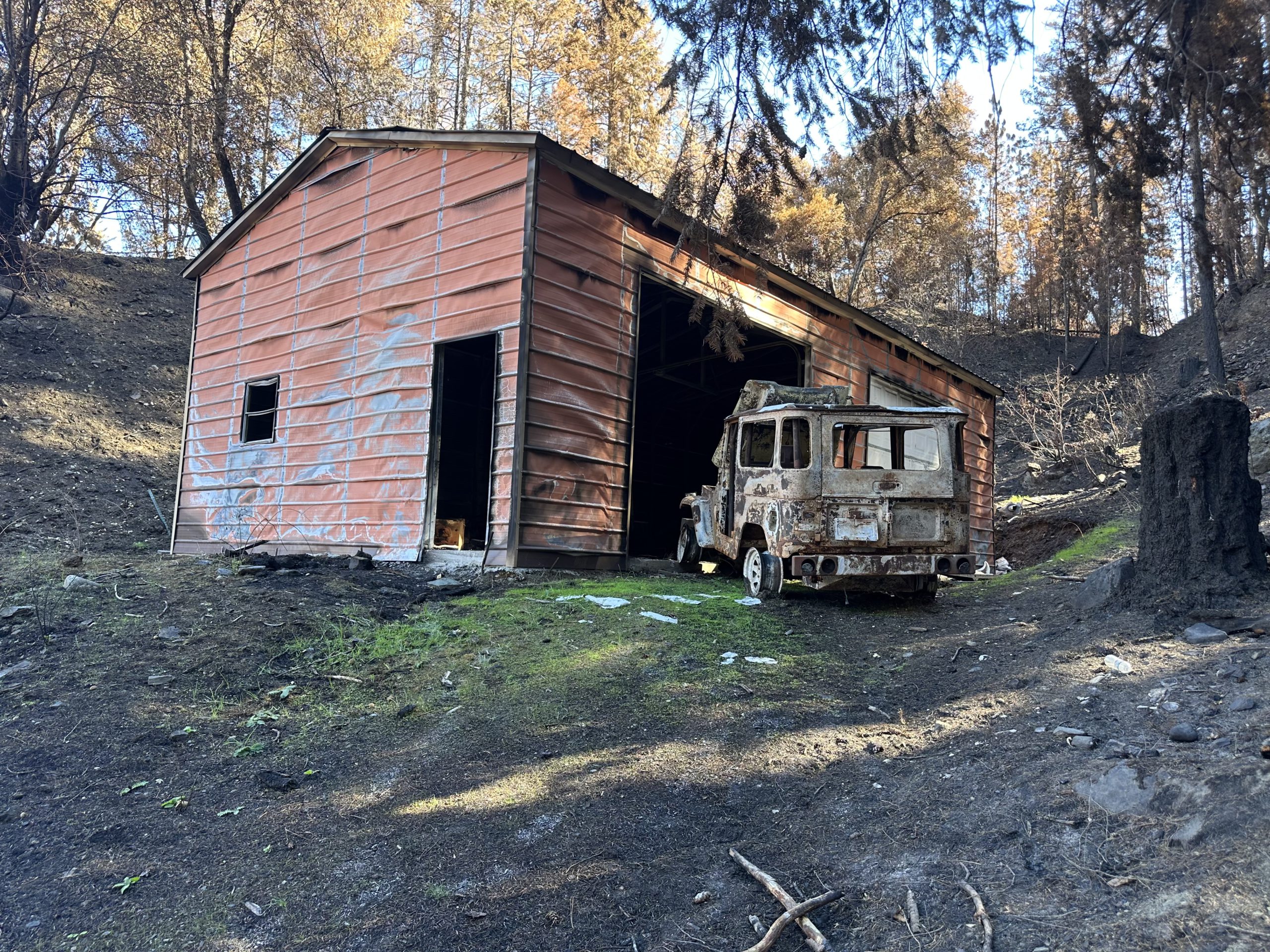 A metal structure with a burned vehicle.