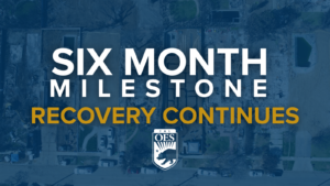 Blue transparent background with the image of properties cleared of fire debris. With text reading Six Month Milestone, recovery continues. And the Cal OES logo.